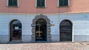 Un bâtiment à la façade en pierre, doté d’une entrée en arc de cercle et d’une enseigne indiquant « PIAZZA GIULIO RUBINI ».