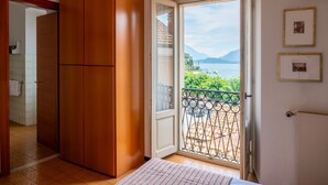 Une chambre dotée d’une grande armoire, d’un balcon avec vue sur la mer et d’une porte donnant accès à la salle de bain.