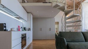 A modern kitchen with white cabinetry, a built-in oven, and a wooden floor. - La Casa del Mercato by Wonderful Italy (Turin)