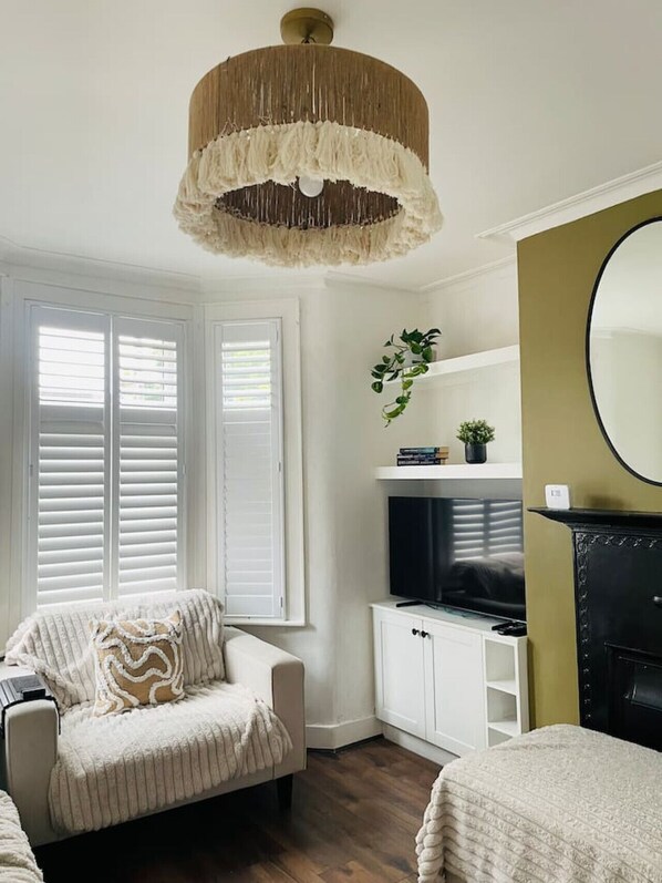 Relax in this inviting living room with a large mirror, TV, and cozy armchair.