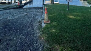 A lakeside dock with a boat launch area, a grassy area, and a clear blue sky. - Deluxe Creekside Cabin nearby Blount's Creek! (Chocowinity)
