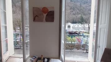 Ein Zimmer mit Blick auf eine Berglandschaft, ein Tisch mit einer Fernbedienung, ein weißes Handtuch und ein Gemälde an der Wand.