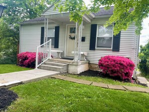A single-story house with a front porch, steps, and a mailbox.