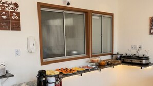 Una cocina con estación de café, un ventanal grande y una cámara de seguridad.