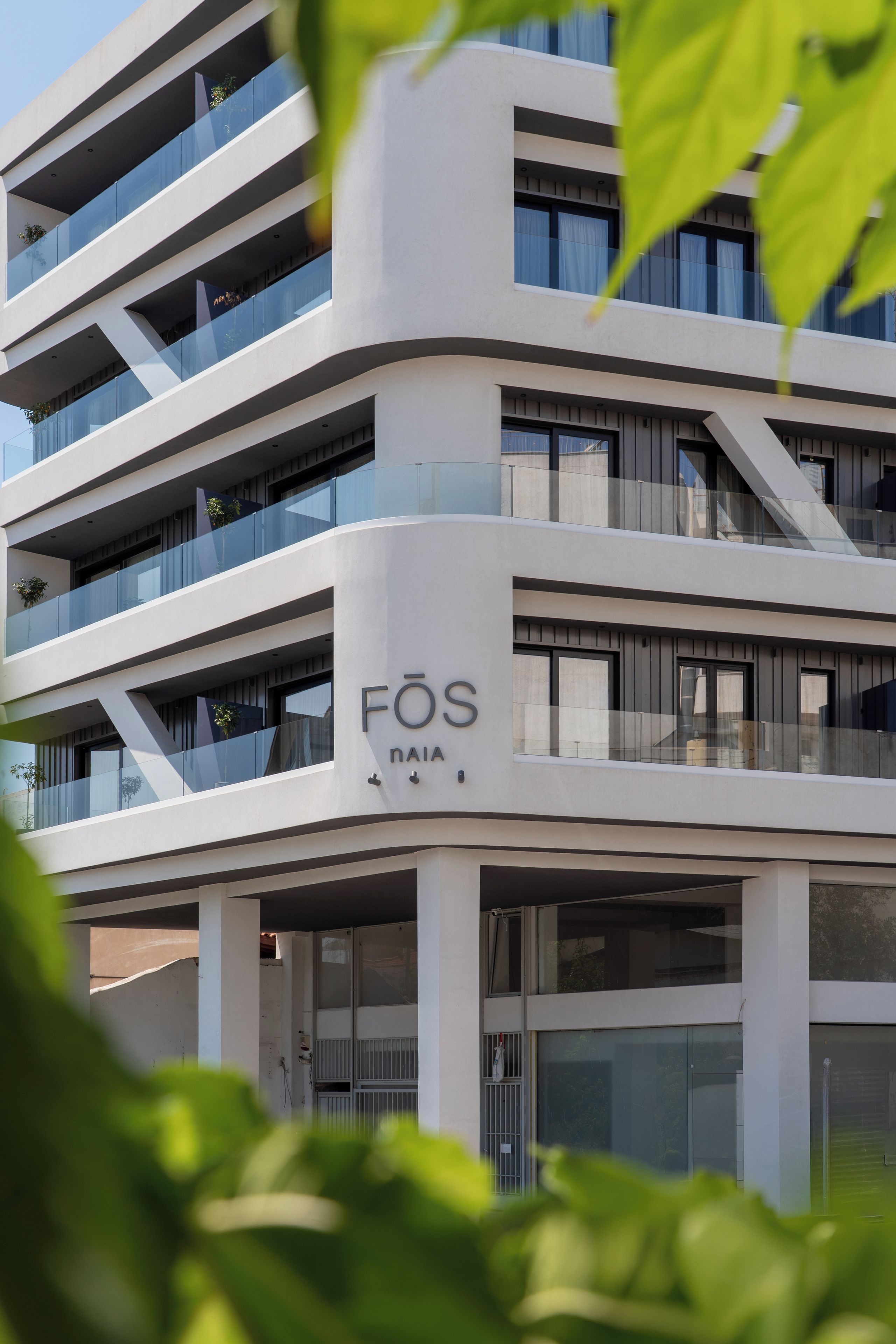 Un edifici modern amb diversos balcons i un rètol que diu 'FOS NAIA'.