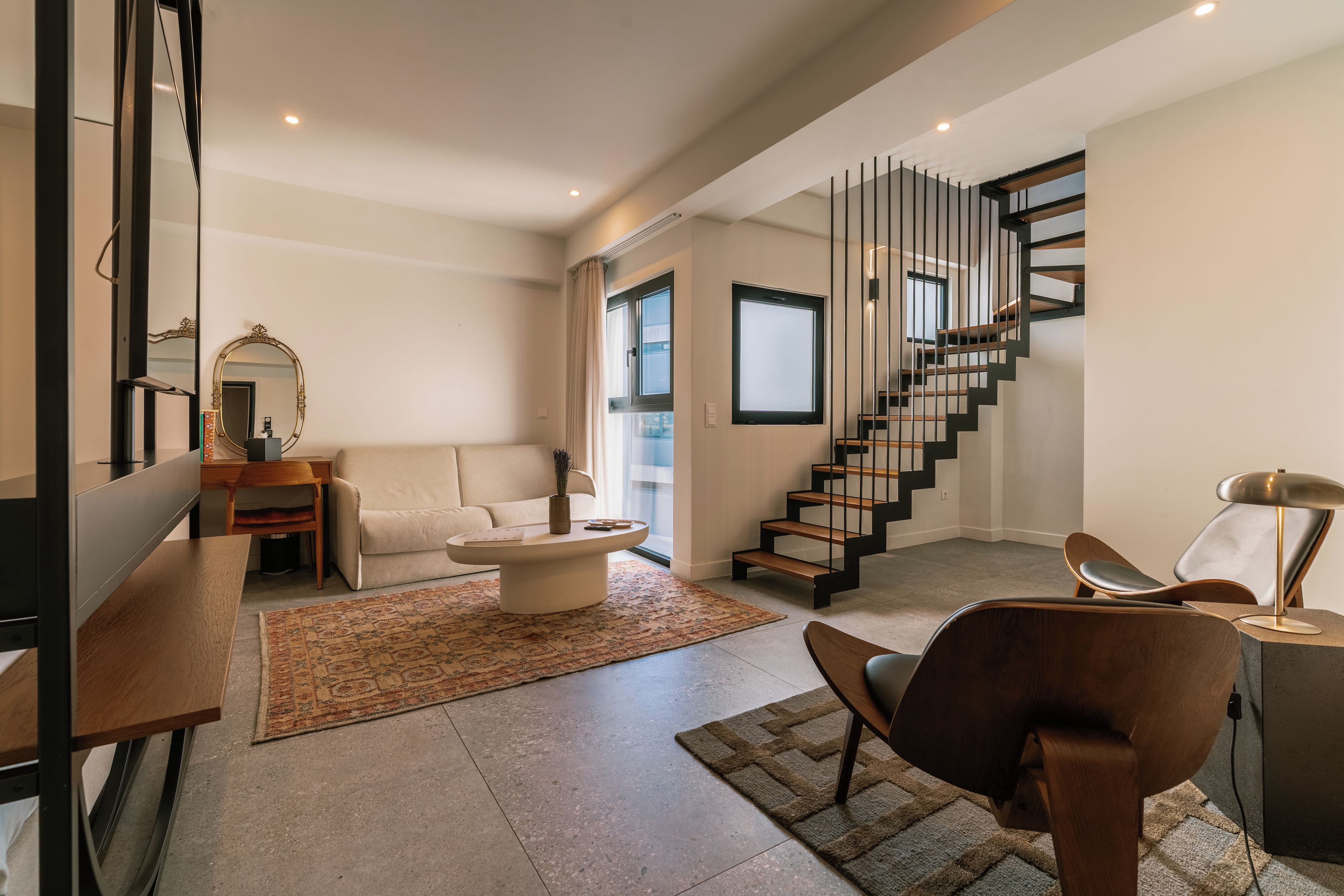 Un salon moderne avec un canapé, une table basse et un escalier au design original.