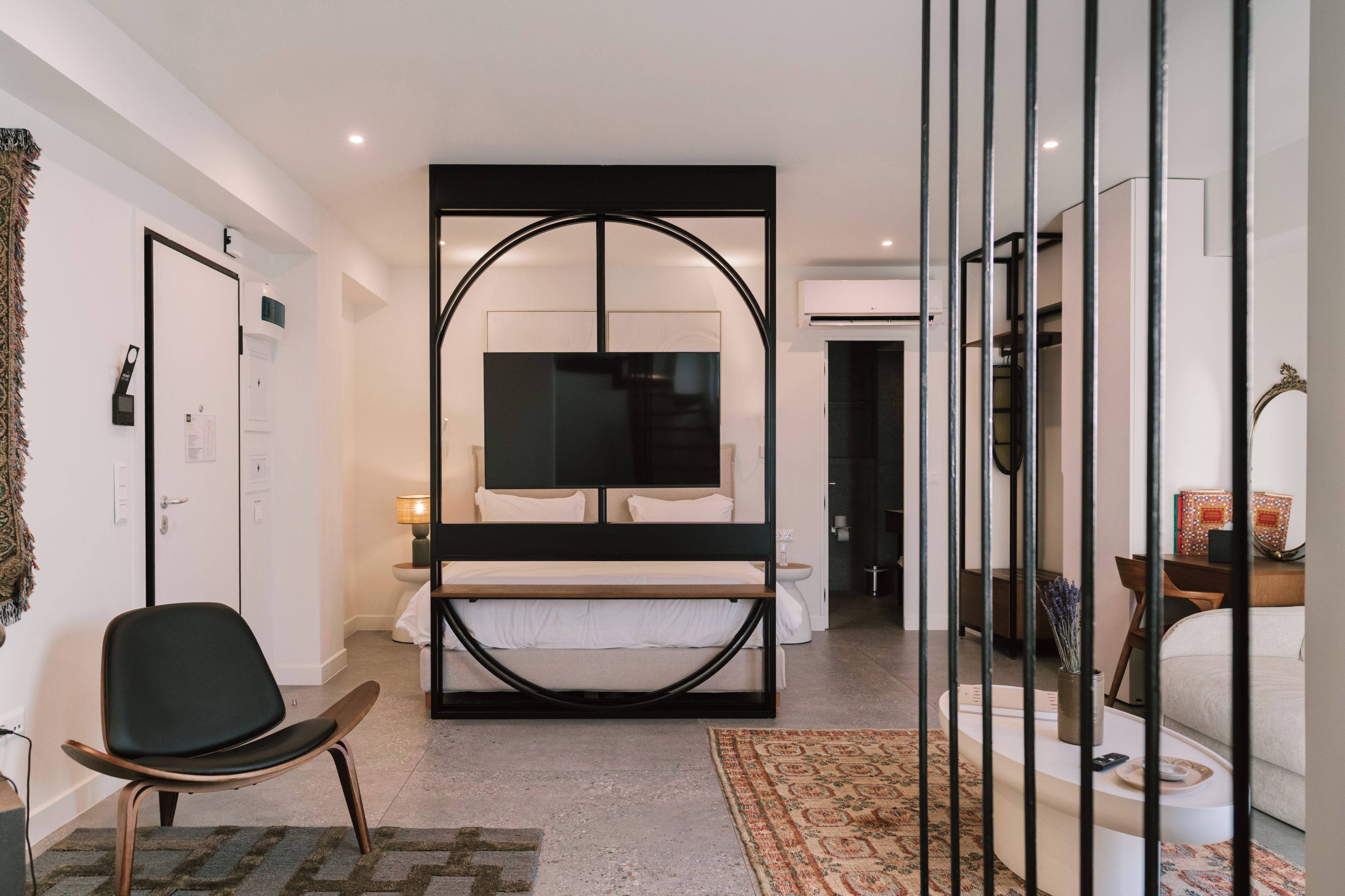 Una habitación de hotel moderna con una cama grande, un escritorio, una silla y un televisor.