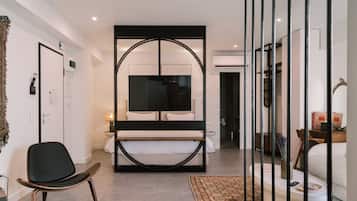 Una habitación de hotel moderna con una cama grande, un escritorio, una silla y un televisor.