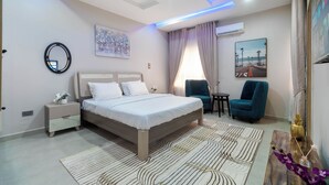 Une chambre moderne avec un grand lit, des tables de chevet, un bureau et une chaise.