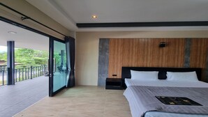 Quarto de hotel moderno com uma cama grande, cabeceira de madeira e varanda com porta de vidro.
