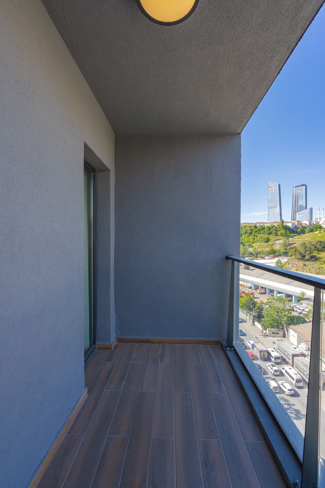 A balcony with a view of a cityscape, including tall buildings and a highway.