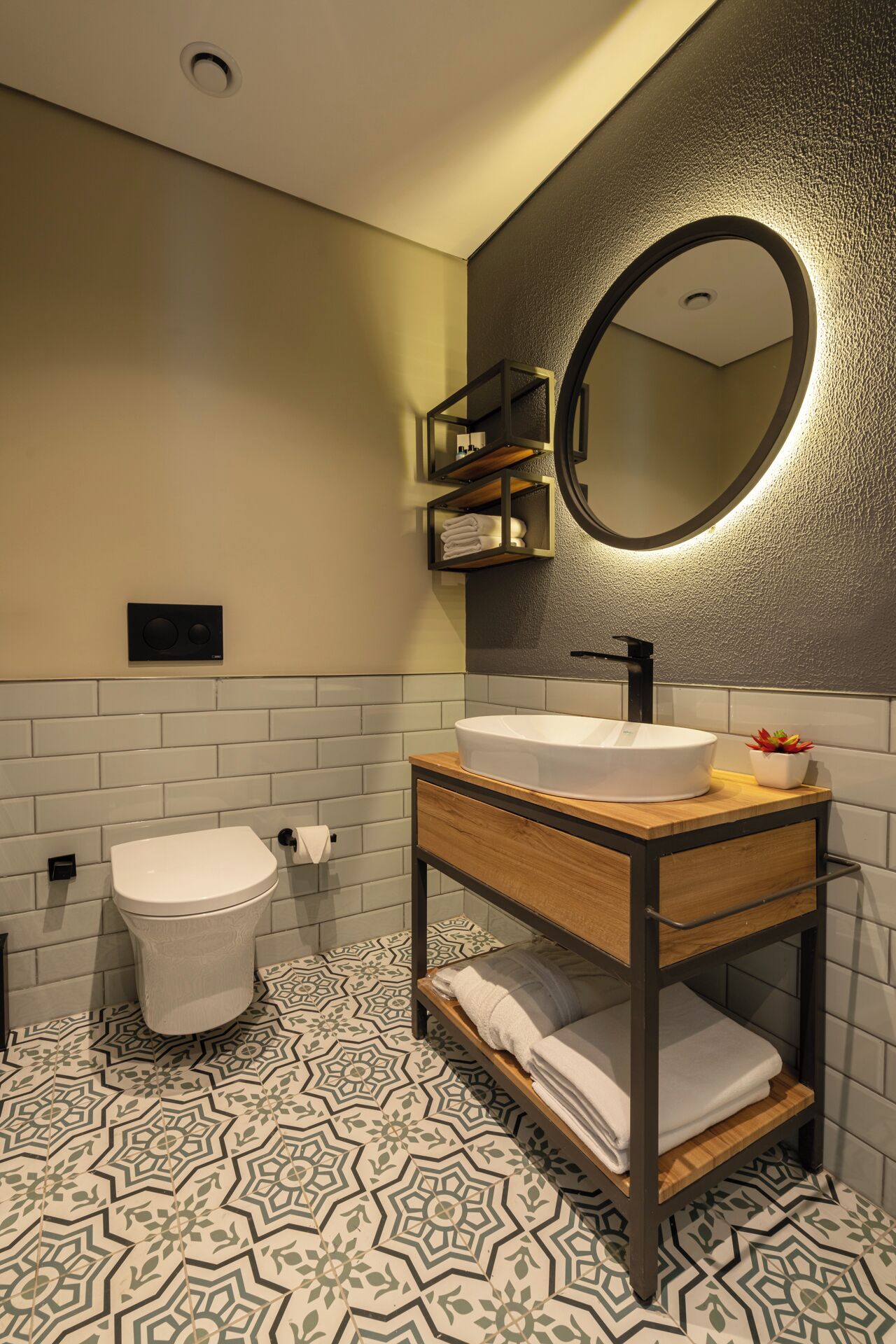 A modern bathroom with a white toilet, a wooden vanity with a sink, and a mirror.