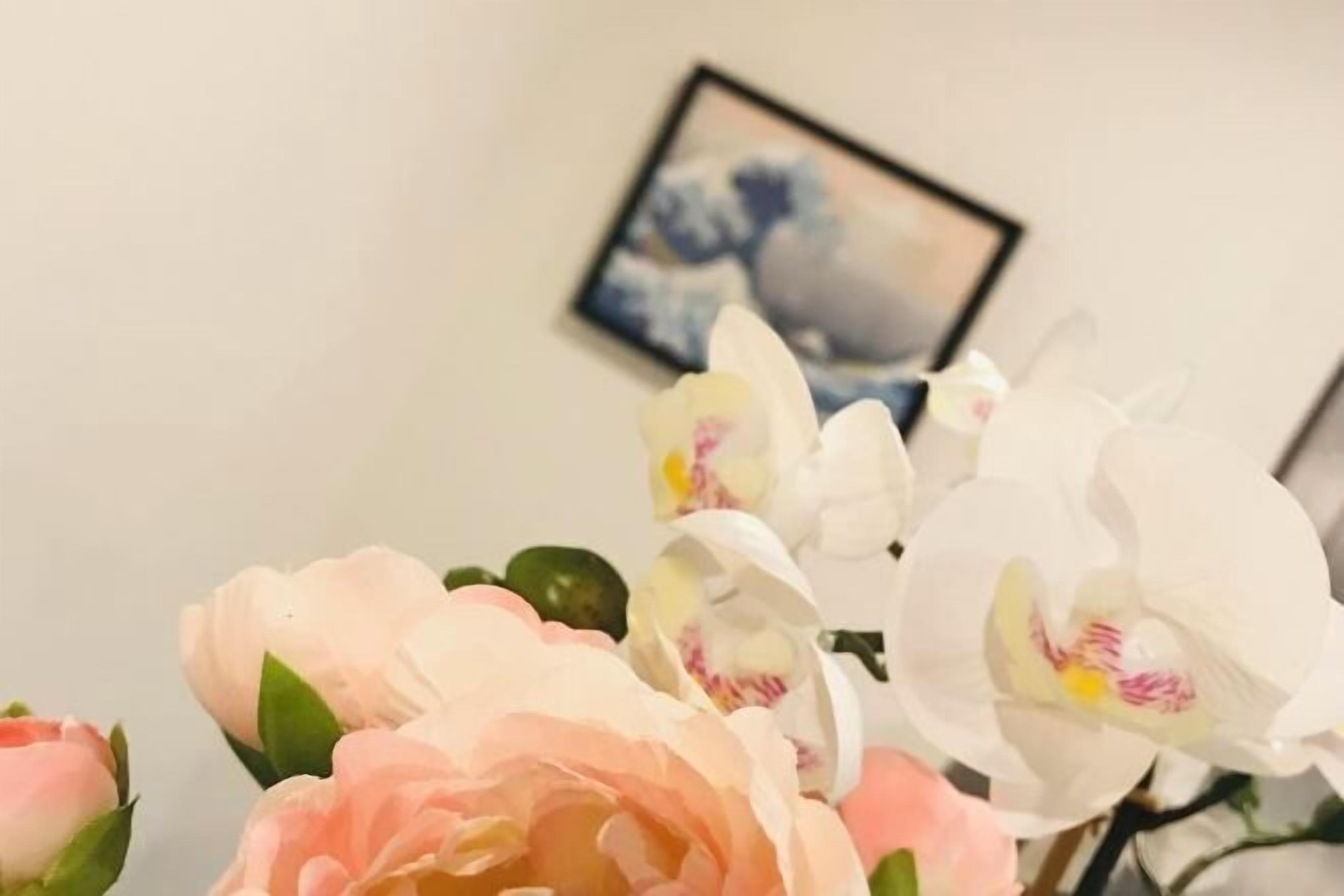 A bouquet of flowers with a painting in the background.