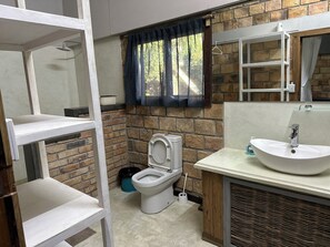 Et badeværelse med toilet, vask og bruser.