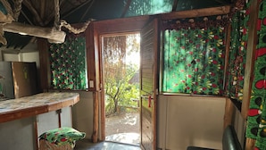 A rustic room with a wooden table, a bench, and a door leading outside.
