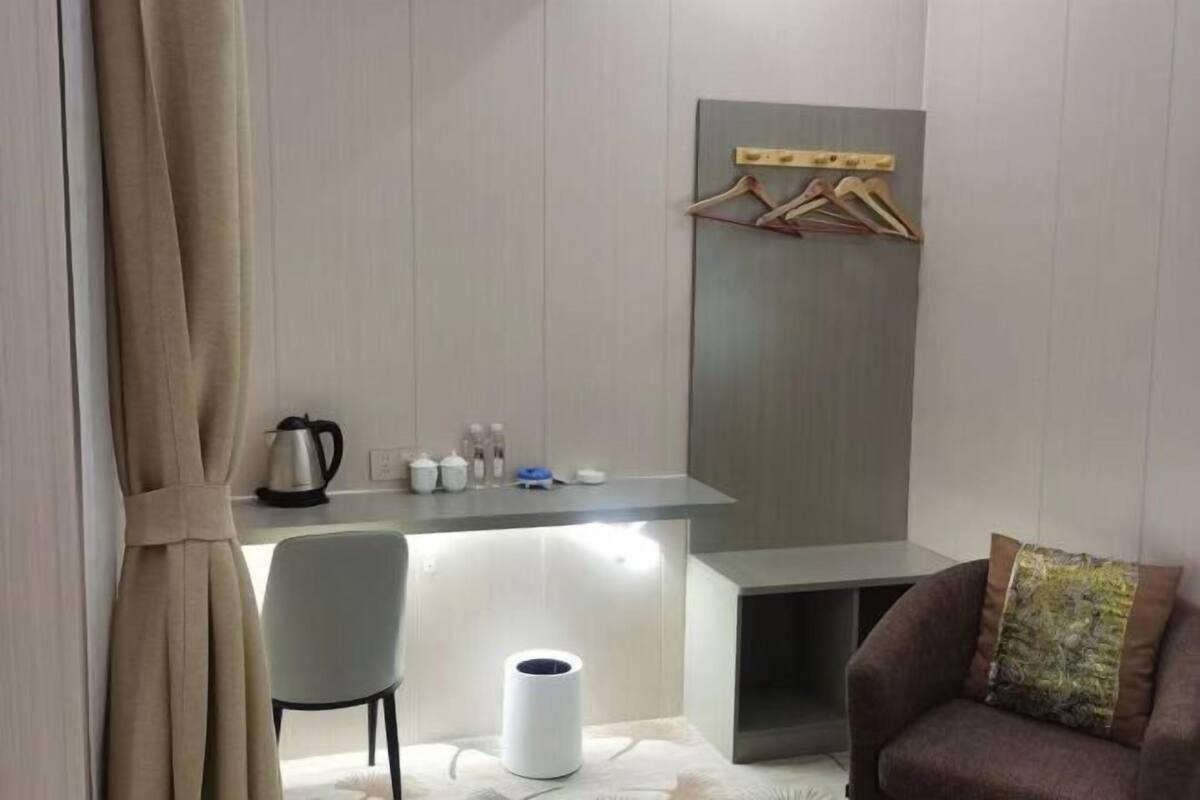 Une chambre moderne équipée d’un bureau, d’une chaise et d’un canapé.