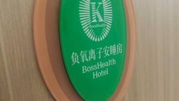 Un letrero verde con el logotipo del Hotel BossHealth y caracteres chinos.