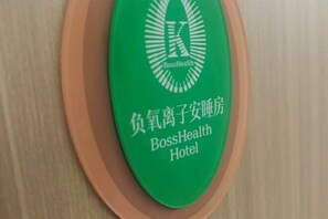 Un letrero verde con el logotipo del Hotel BossHealth y caracteres chinos.