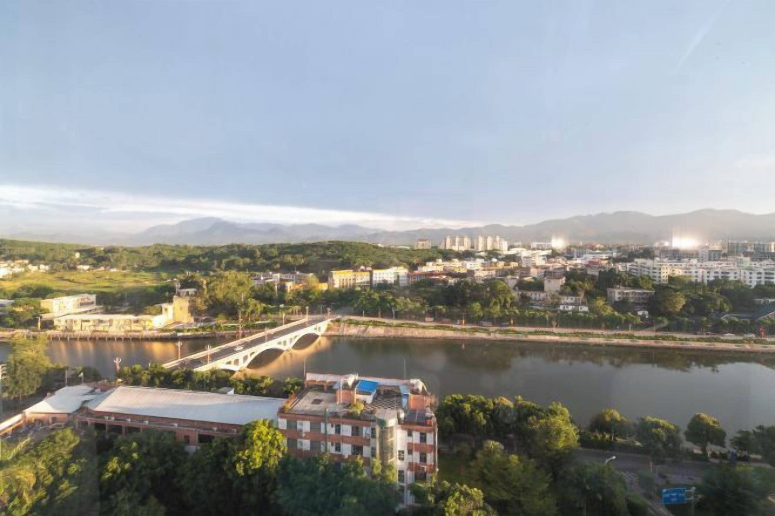 A cityscape with a river, a bridge, and buildings in the distance.