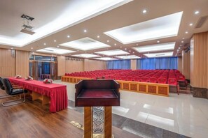 Ein Konferenzraum mit einem langen Tisch, Stühlen und einem Rednerpult.