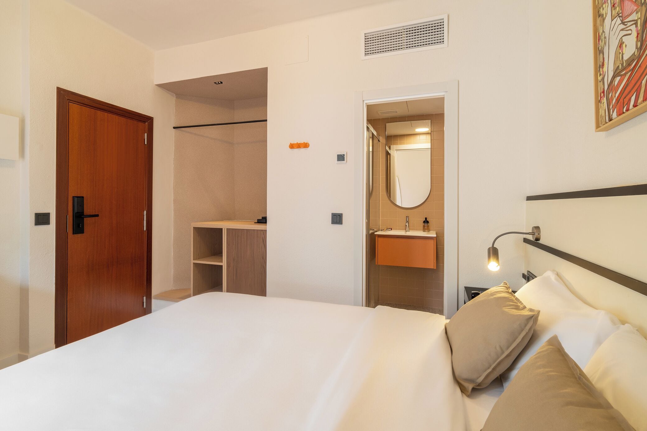 Habitació d'hotel amb llit, bany i dutxa.