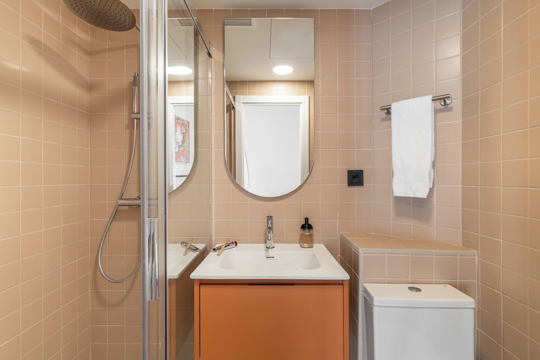 Une salle de bain équipée d’une douche, d’un lavabo, d’un miroir et de toilettes.