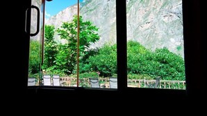 Habitación con vistas a un paisaje montañoso a través de un amplio ventanal.