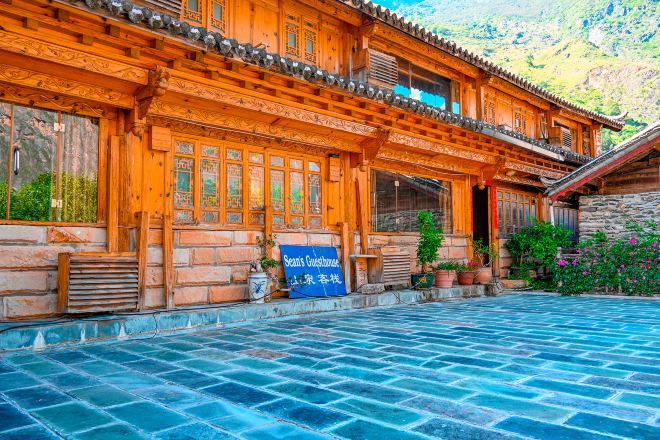 A traditional wooden building with a tiled courtyard.