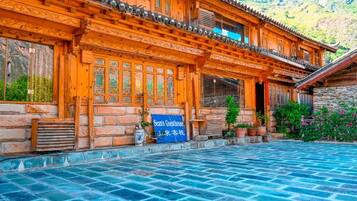 A traditional wooden building with a tiled courtyard.