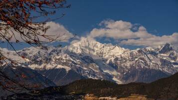 Cordillera con picos nevados, cielo despejado y valle con edificios.