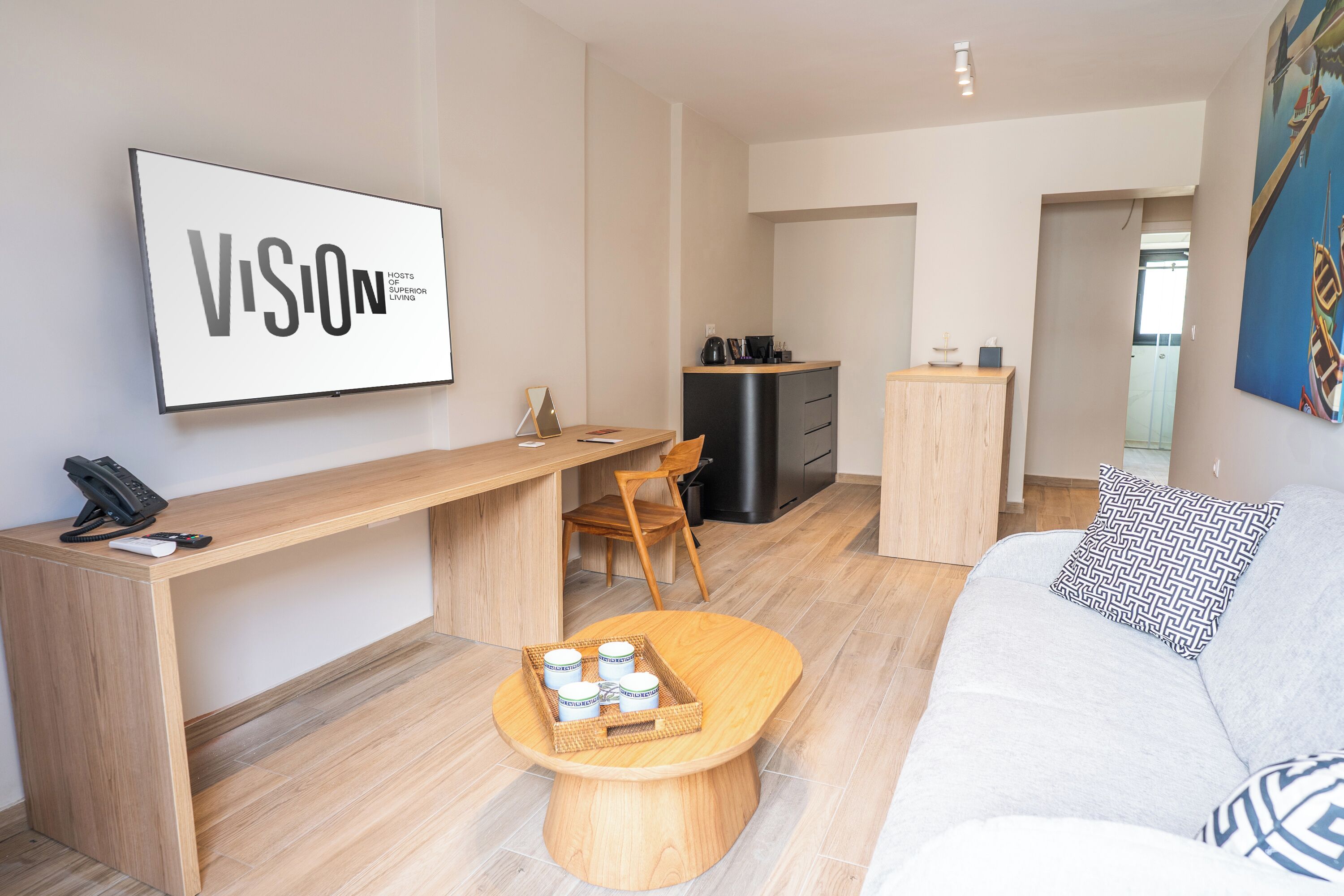 A modern living space with a wooden desk, a sofa, and a dining area.