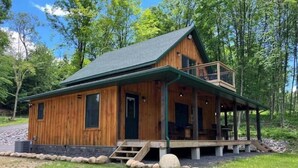 A wooden cabin with a balcony, surrounded by trees. - Creekside Cabin with Lake Access , Brand new build !!! (Remsen)