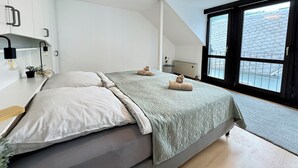 A modern bedroom with a bed, a desk, and a large window. - Erholung pur am Rhein (Sankt Goar)