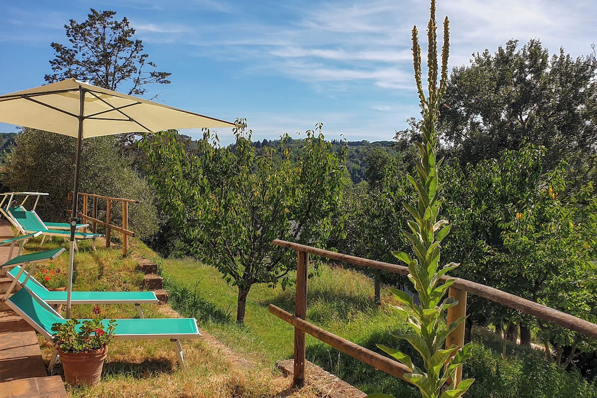 Une terrasse avec des sièges extérieurs et une vue sur le paysage environnant.