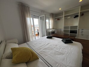 Een hotelkamer met een bed, een bureau en een kledingkast.