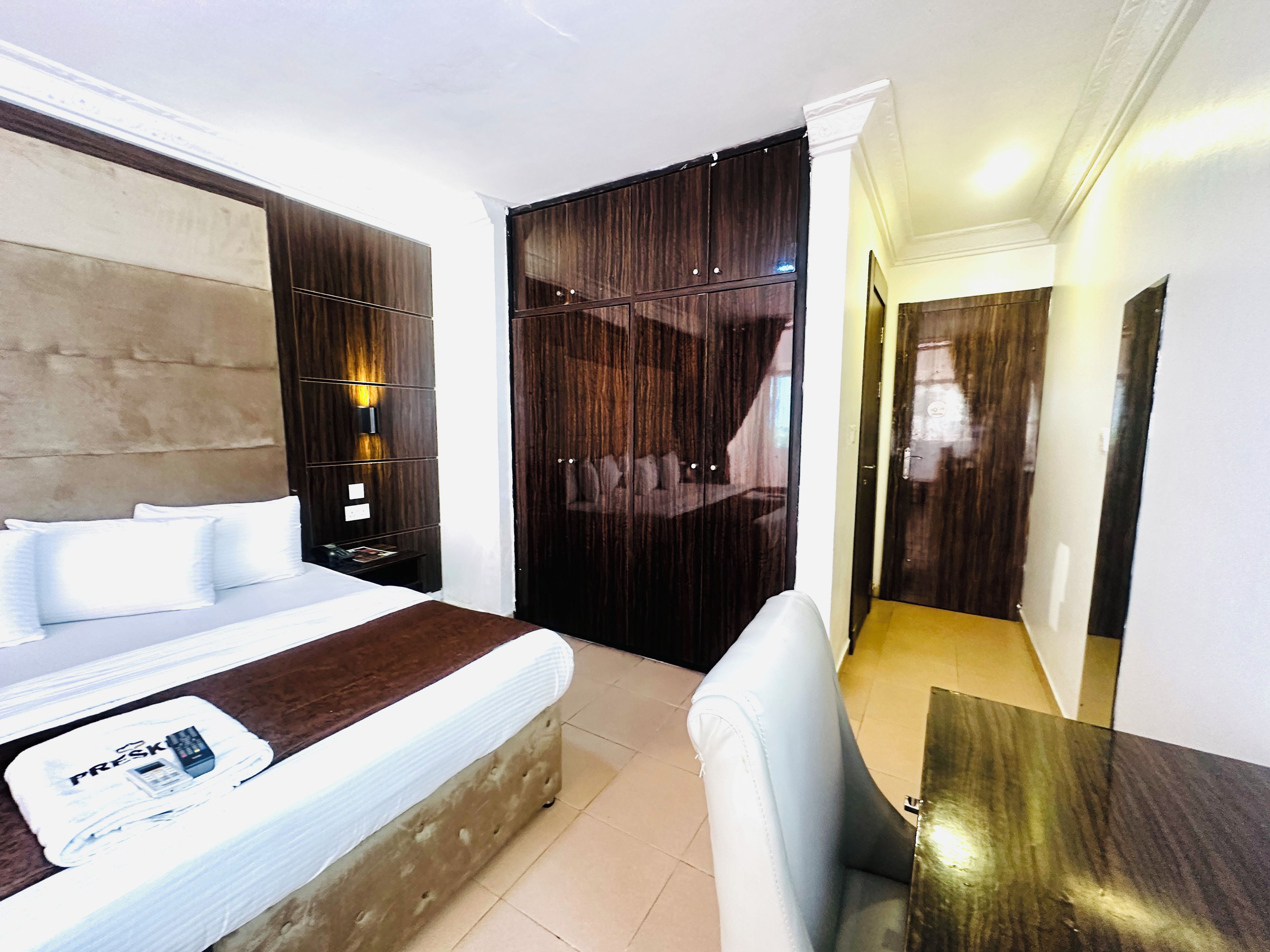 A modern bedroom with a bed, bedside table, and a wardrobe.