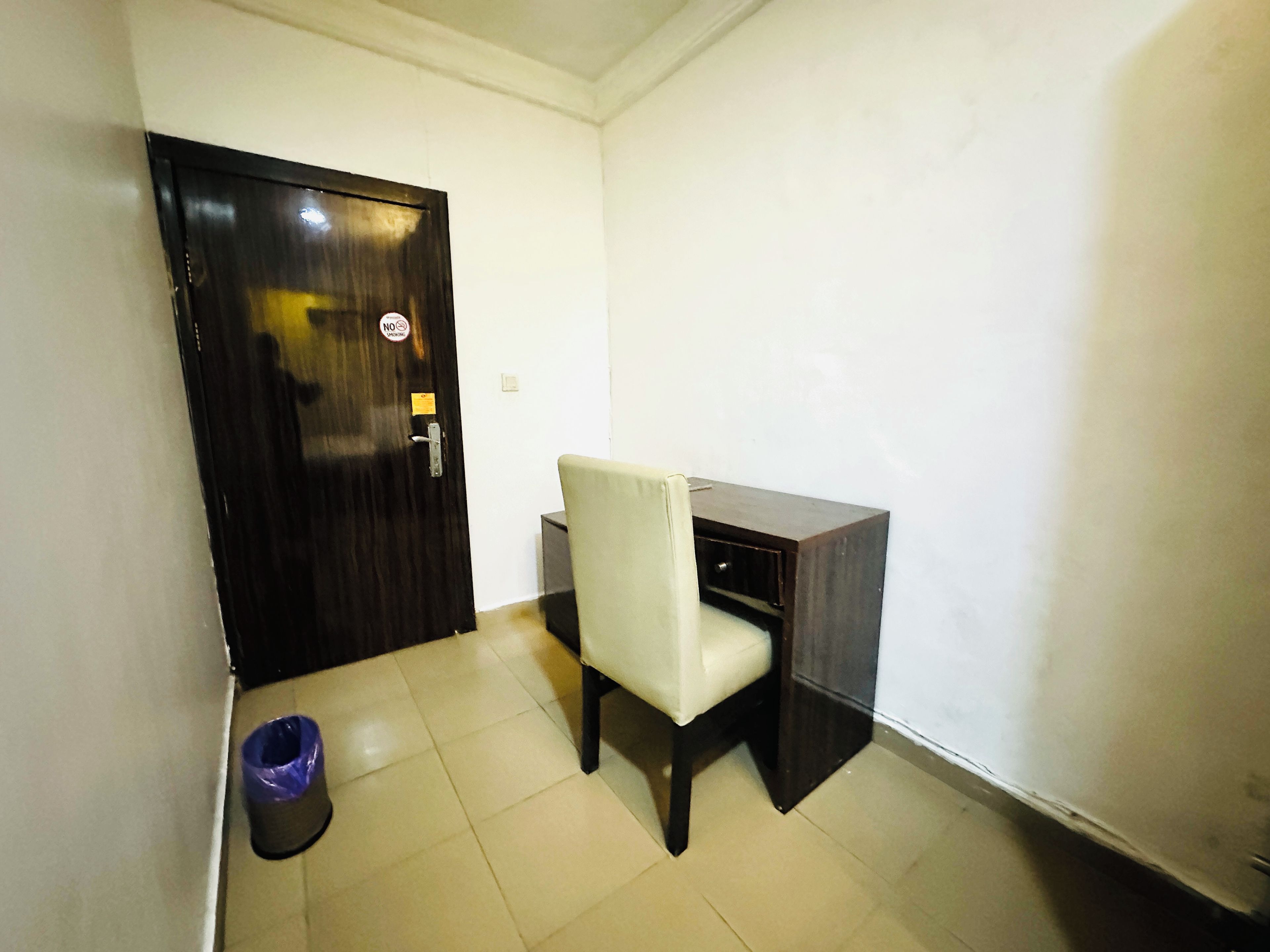 A room with a desk, chair, and a closed door.