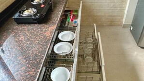 A kitchen with a granite countertop, a gas stove, and a dish rack.