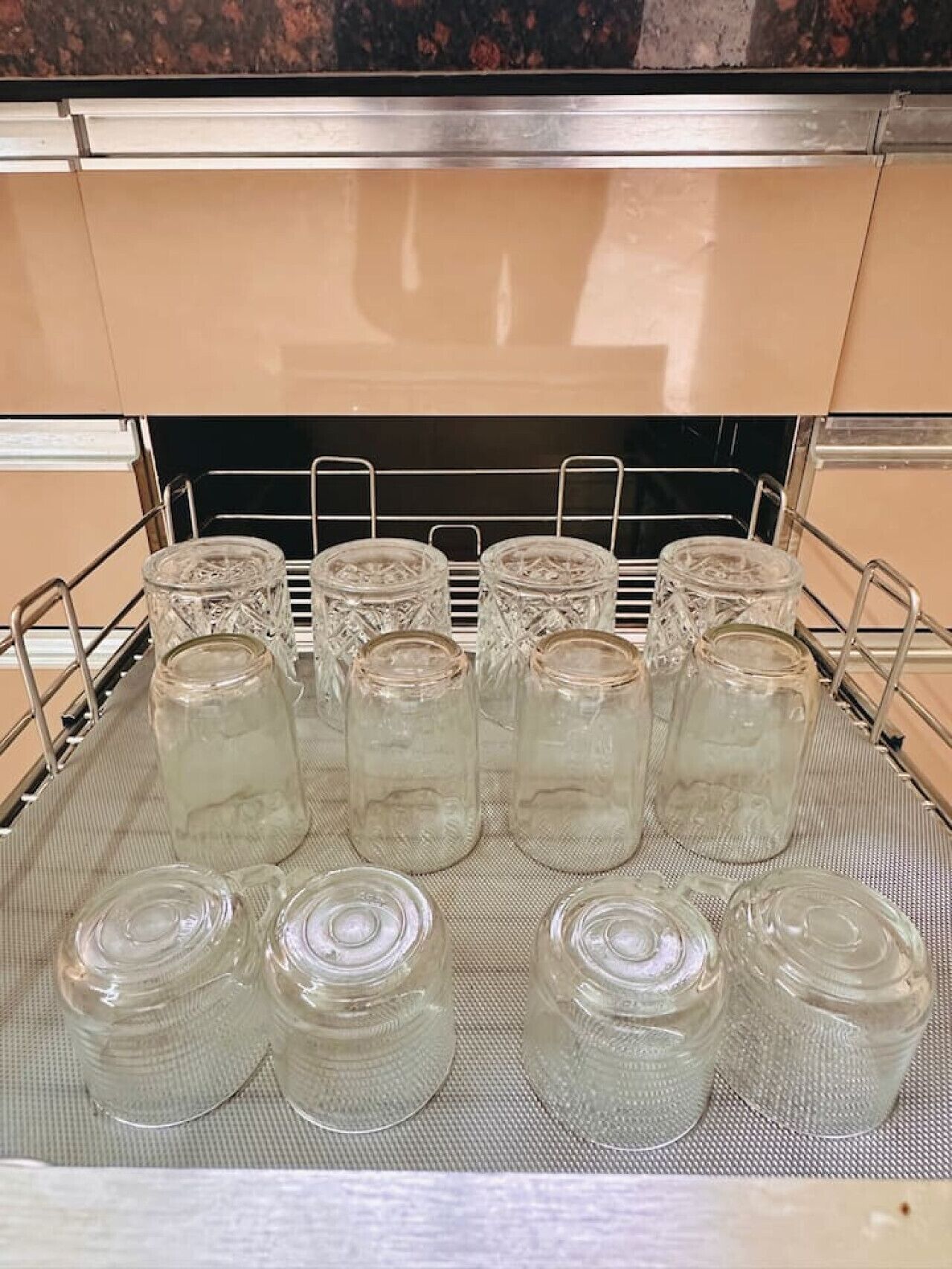 A kitchen with a metal rack holding clear glass jars.