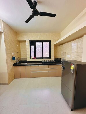 Refrigerador, placa de cocina, utensilios de cocina, mesa de comedor