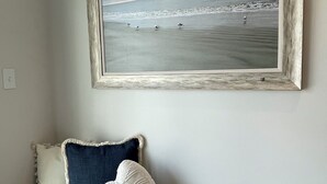 A room with a framed beach scene on the wall, a bench with pillows, and a light-colored floor. - Beach block/Ocean View 82nd Street (Ocean City)