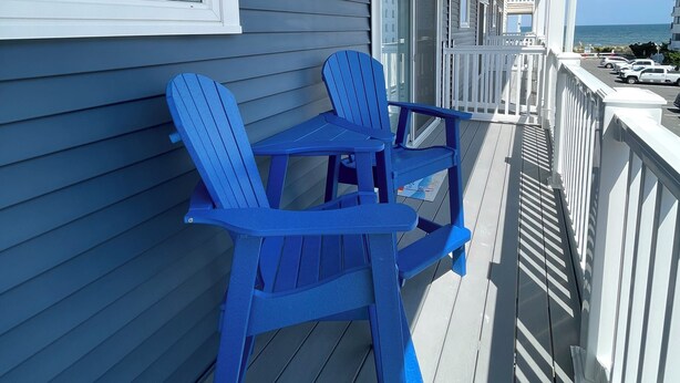 A covered outdoor area with a table and chairs, a railing, and a view of the ocean. - Beach block/Ocean View 82nd Street (Ocean City)