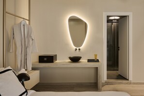 A modern bathroom with a large mirror, a black radio, and a bowl on the countertop. - Finders Top Floor Apartments (Athens)