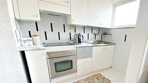 A compact kitchen with white cabinets, a stainless steel oven, a sink, and a small countertop. - Complete and bright apartment in Monfalcone  (Monfalcone)