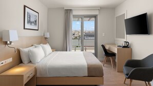 A hotel room with a bed, bedside tables, a desk, a chair, and a TV. - Gallery Central Piraeus Port (Piraeus)
