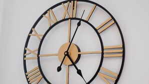 A round wall clock with Roman numerals and a minimalist design. - Cosy Liverpool Apartment (Liverpool)