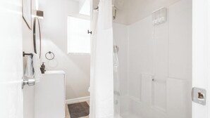 Un baño moderno con ducha, inodoro y lavamanos.