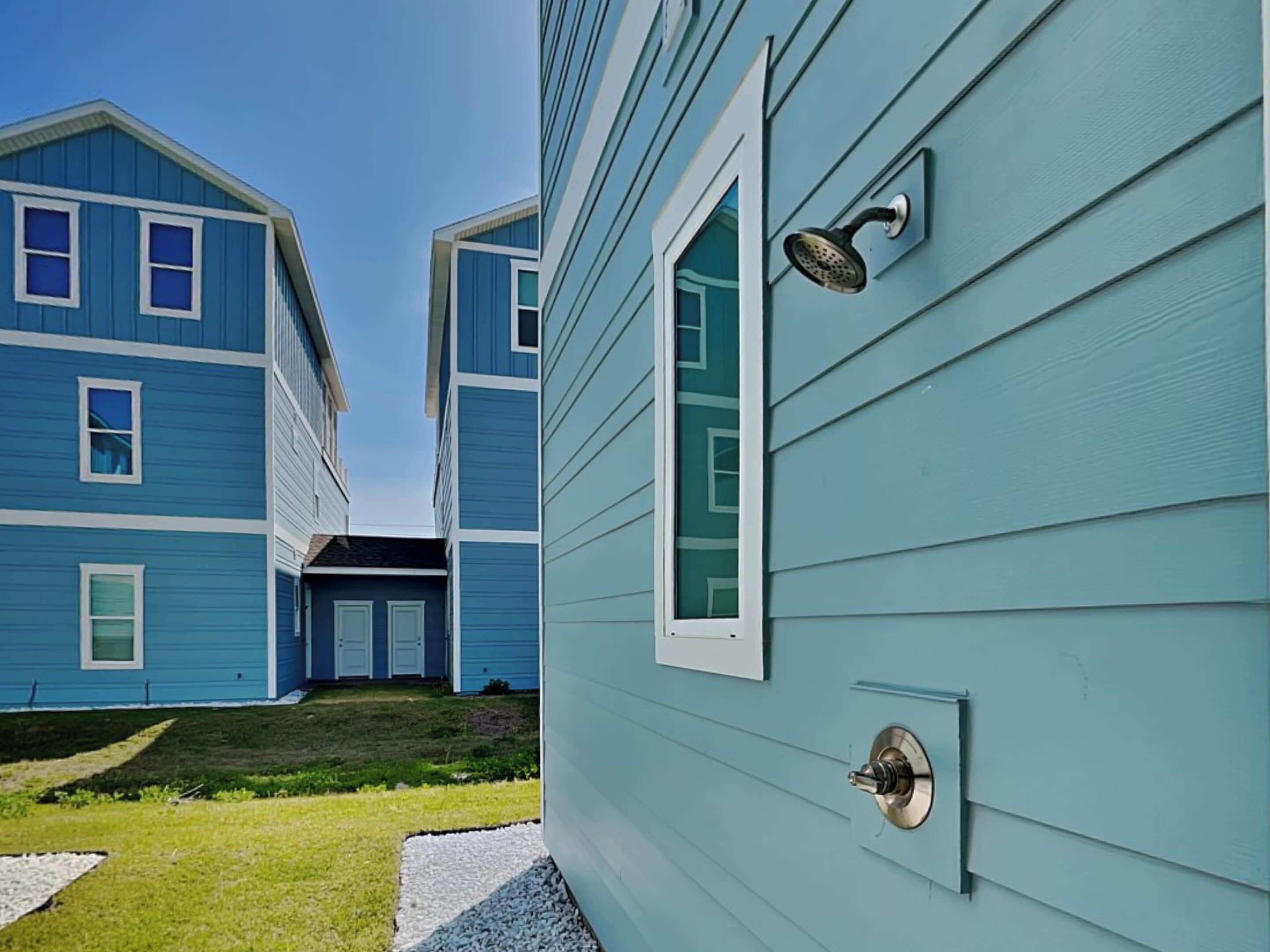 A residential building with a blue exterior, a visible door with a peephole, and a small window.