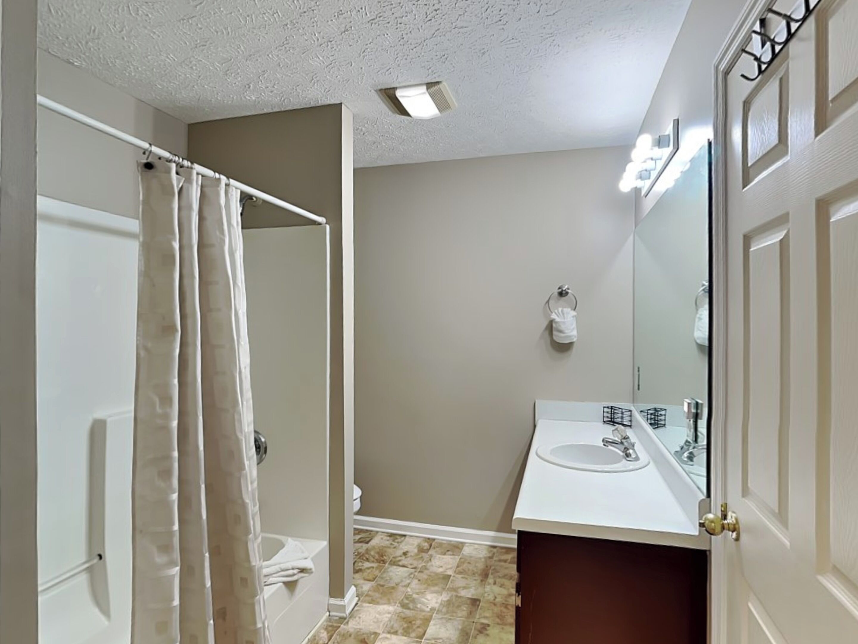 A bathroom with a shower, toilet, and sink.