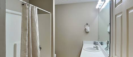 A bathroom with a shower, toilet, and sink.